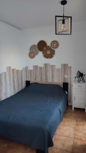 - une chambre avec un lit bleu et un mur en bois dans l'établissement T2 RDC avec Jardin, Cap d'Agde, Secteur Falaise, 100 m plage, Clim, WIFI, Parking, au Cap d'Agde