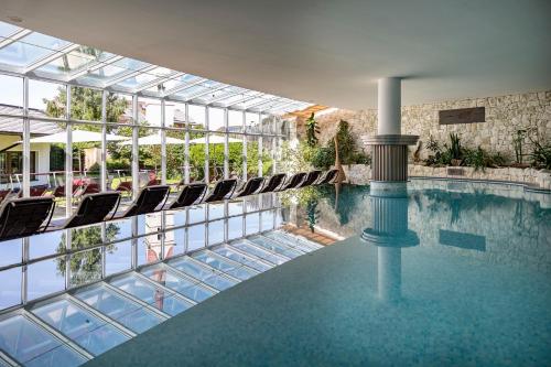 una piscina en un edificio con tumbonas en Artnatur Dolomites Hotel & Spa en Siusi