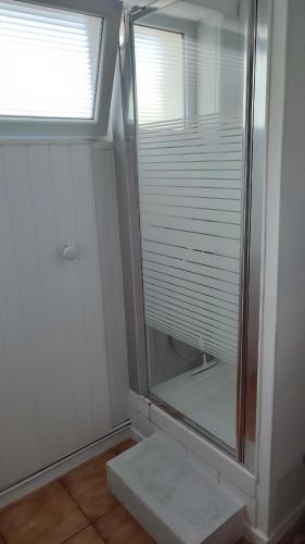 une salle de bain avec une douche en verre avec une fenêtre dans l'établissement T2 RDC avec Jardin, Cap d'Agde, Secteur Falaise, 100 m plage, Clim, WIFI, Parking, au Cap d'Agde