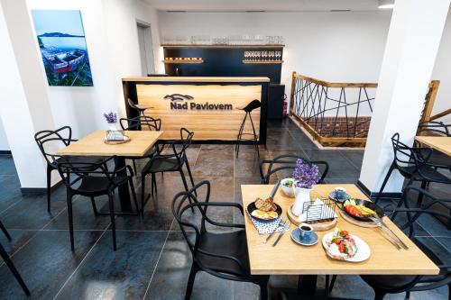a restaurant with tables and chairs with food on them at Penzion Nad Pavlovem in Pavlov
