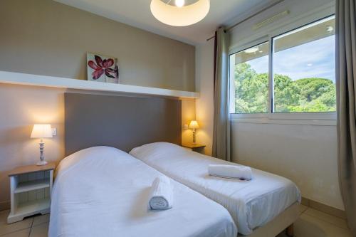 a hotel room with two beds and a window at Residhotel Résidence Pont du Gard in Remoulins