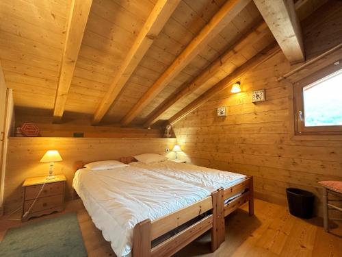 a bedroom with a bed in a wooden cabin at Duplex spacieux proche des remontées, balcon, animaux admis, WIFI - FR-1-624-13 in Samoëns