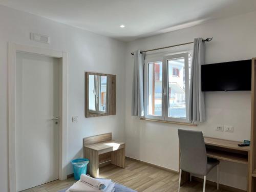a room with a desk and a window and a chair at Salsedine Tropea Capo Vaticano in Santa Domenica