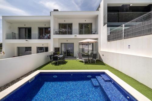 an exterior view of a house with a swimming pool at Modern Villa with pool and garage by Soulplaces in Sobreda