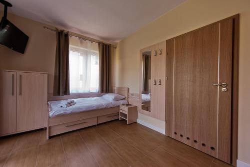 a small bedroom with a bed and a window at Świętokrzyska Polana - Medical Resort in Chrusty