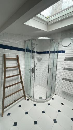 une douche avec une porte vitrée dans une salle de bain dans l'établissement Maison jardin proximité Bayeux, Arromanches, à Ranchy