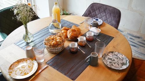 un tavolo di legno con sopra croissant e pane di La Longère a La Menitré
