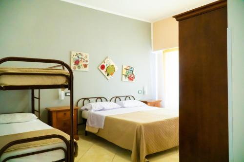 a bedroom with two bunk beds and a window at Ostello Bortone in Castelnuovo Cilento