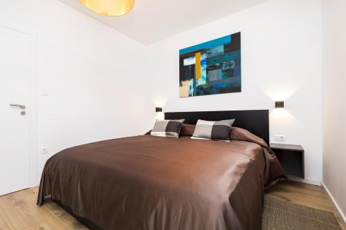 a bedroom with a large bed in a white room at Apartments Laura in Mali Lošinj