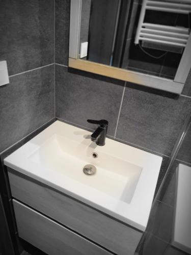 un lavabo blanc dans une salle de bain avec un miroir dans l'établissement Logement privé dans Villa avec piscine, à Dalhunden
