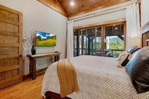 a bedroom with a bed and a large window at Copperline Lodge - Luxury Creekside Retreat - Creekside Views, Hot Tub, Game Room, Outdoor Fireplaces, Chef Kitchen, Fire Pit - in Epworth