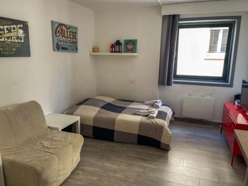 une petite chambre avec un lit et un canapé dans l'établissement Spacieux studio au centre, à Strasbourg