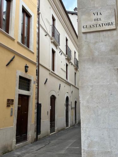 an alley with a sign on the side of a building at In Media Urbe NEXT in LʼAquila