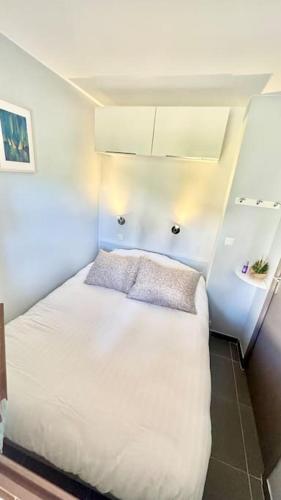 une chambre avec un lit blanc dans une pièce dans l'établissement Vue mer appartement ,Plage la nartelle,avec loggia, sainte-maxime, France, à Sainte-Maxime