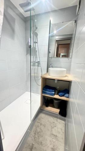 une salle de bain blanche avec une douche et un lavabo dans l'établissement Vue mer appartement ,Plage la nartelle,avec loggia, sainte-maxime, France, à Sainte-Maxime