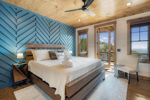 Un dormitorio con una cama y una pared azul. en Mountain Air - Luxury Mountain View Cabin, en Blue Ridge