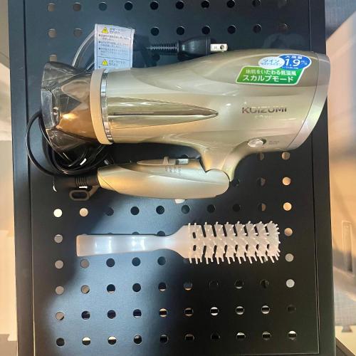 a hair dryer in a display case with a hairbrush at Sound Garden Biei, Cricket in Biei