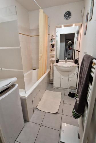 une salle de bain avec une baignoire et un lavabo dans l'établissement Res au calme et arboree, à Dax