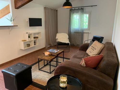 a living room with a couch and a table at Haut de maison 65m2 avec jardin in Callian