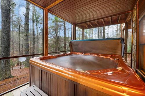 an orange tub in a screened in porch with trees at Storybook Hideaway - Pet Friendly - Toccoa River in Blue Ridge