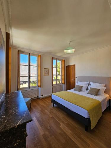 a bedroom with a large bed and two windows at Villa Bajocasse, maison Bayeux Centre Historique - 4 chambres in Bayeux