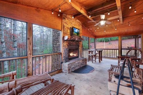 a screened in porch with a fireplace and chairs at Storybook Hideaway - Pet Friendly - Toccoa River in Blue Ridge