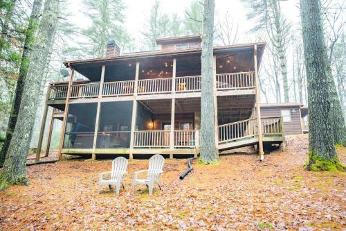 a large house with two chairs in the woods at Storybook Hideaway - Pet Friendly - Toccoa River in Blue Ridge