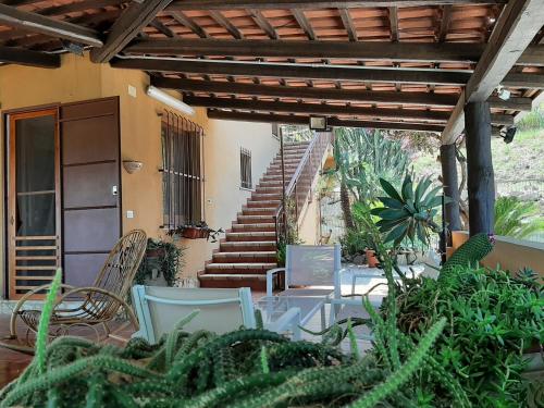 a patio with tables and chairs and a staircase at Villa Panorama in Zambrone
