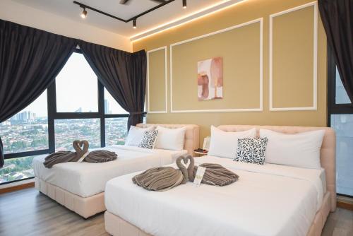 two beds in a room with large windows at Midvalley Southkey Mosaic Suite by Nest Home in Johor Bahru
