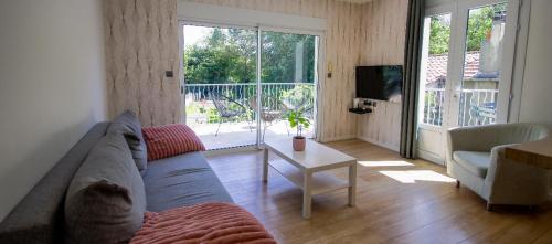 un salon avec un canapé et une table dans l'établissement La maison des roses 3 Avignon, à Villeneuve-lès-Avignon