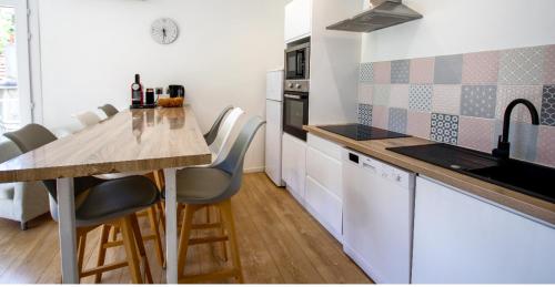 une cuisine avec un comptoir, une table et des chaises dans l'établissement La maison des roses 3 Avignon, à Villeneuve-lès-Avignon