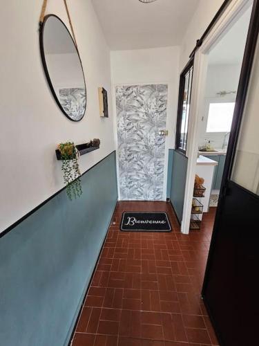 un couloir avec un miroir et un sol carrelé dans l'établissement Superbe vue mer pour ce T3, à Narbonne-Plage