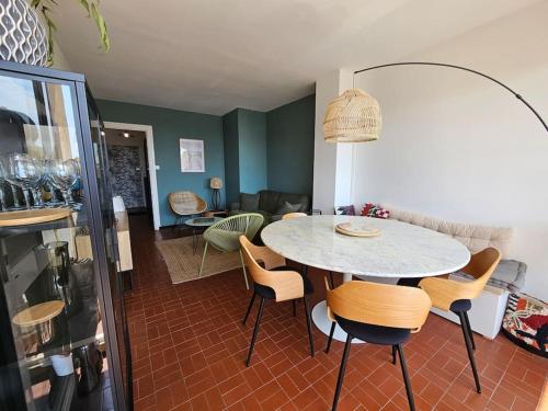 une cuisine et une salle à manger avec une table et des chaises dans l'établissement Superbe vue mer pour ce T3, à Narbonne-Plage