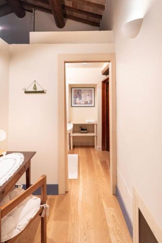 a bathroom with white walls and a wooden floor at La Vittoria 10 – La Soglia della Val d’Orcia in Chianciano Terme