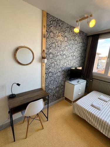 a bedroom with a desk and a bed and a mirror at Joli studio au coeur de Valence 41 in Valence