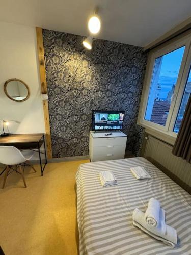 a bedroom with a bed and a television in it at Joli studio au coeur de Valence 41 in Valence