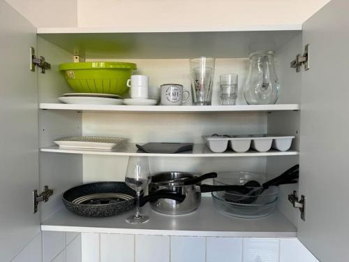 a kitchen shelf with bowls and dishes and a sink at Joli studio au coeur de Valence 41 in Valence