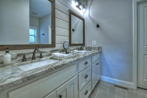 Un baño con dos lavabos y un espejo grande. en Serenity Now - Game Room and Mountain Views - Hot Tub, Cozy Fireplace, Modern Amenities, Billiards Table, Porch Fire Pit - Cherr, en Cherry Log