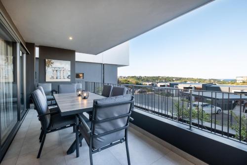 a dining room with a table and chairs on a balcony at Moyana 14 in Ballito