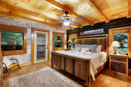 Un dormitorio con una cama y un ventilador de techo. en Mountaintown Creek Lodge - Creek Front Fish Cabin - Creekside Relaxation With Fishing, Firepit, Hot Tub, Free-Standing Gas Heate, en Ellijay