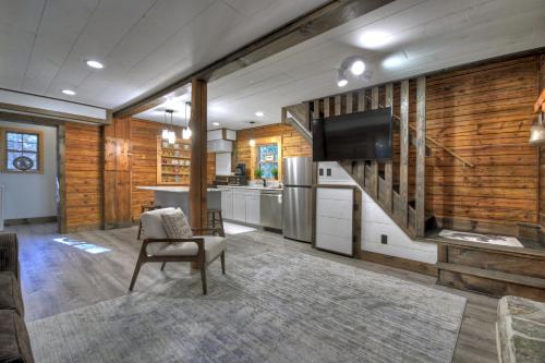 a living room with a television and a kitchen at Happy Trout Hideaway - Creek Views Of Hot House Creek, Hot Tub, Outdoor Fire Pit, Cozy Atmosphere - Mineral Bluff, GA in Mineral Bluff