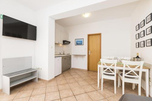 a kitchen and dining room with a table and chairs at Apartments Laura in Mali Lošinj