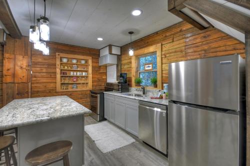 a kitchen with wooden walls and a stainless steel refrigerator at Happy Trout Hideaway - Creek Views Of Hot House Creek, Hot Tub, Outdoor Fire Pit, Cozy Atmosphere - Mineral Bluff, GA in Mineral Bluff