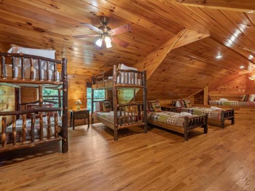 a bedroom with bunk beds in a log cabin at Medley Sunset Cove - Lake Blue Ridge Cabin Rental minutes to Downtown - Blue Ridge, GA in Morganton