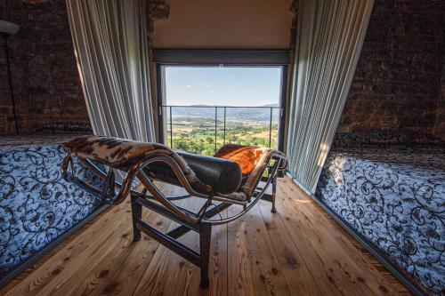 een slaapkamer met een stoel en een groot raam bij Torre di Riosecco in Arezzo