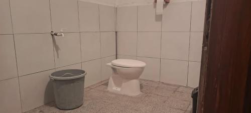 a bathroom with a toilet and a trash can at Hendi Homestay in Gili Gede