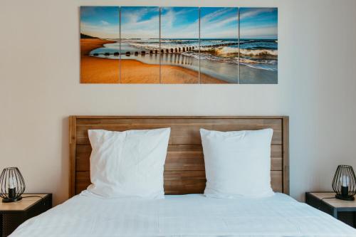 - une chambre avec un lit et une peinture de la jetée dans l'établissement Perret, au Havre