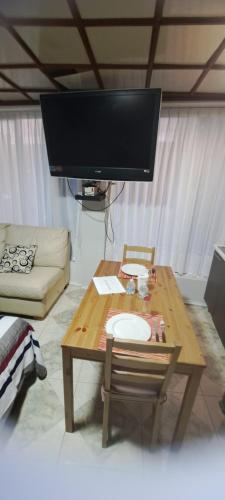 a living room with a wooden table and a flat screen tv at Encantadoras Habitaciones Privadas Del Valle in Mexico City