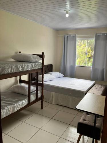 a bedroom with two bunk beds and a window at Geminado da mada casa 3 in Penha