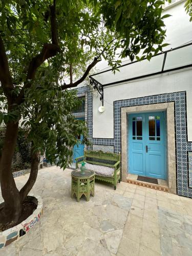 a building with a blue door and a bench at Dar El Rezk in Tunis